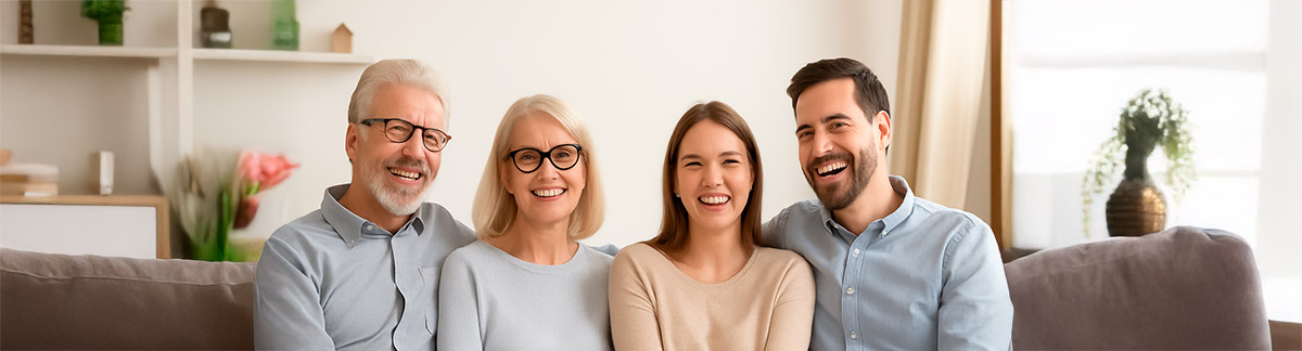 Familia sonriendo junta en la sala de su casa